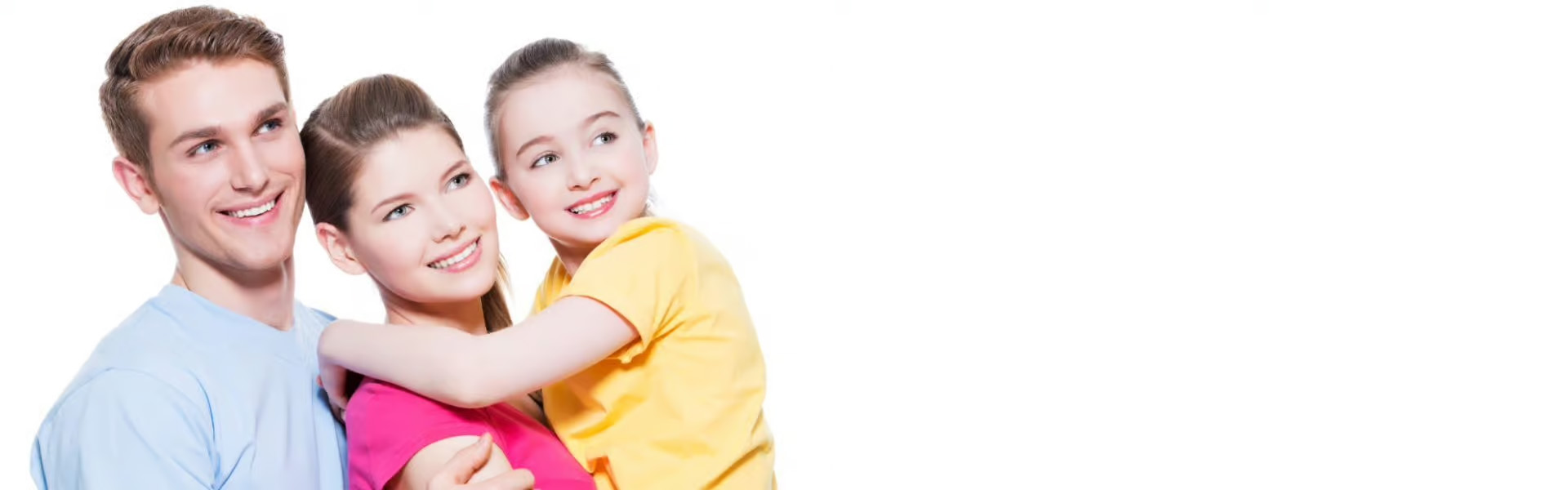 The image shows a family of four people posing together with smiles two adults are hugging each other while holding children, one adult is standing behind them, and they all appear happy and content.